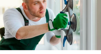 Vitrier positionnant des ventouses sur un vitrage à déposer
